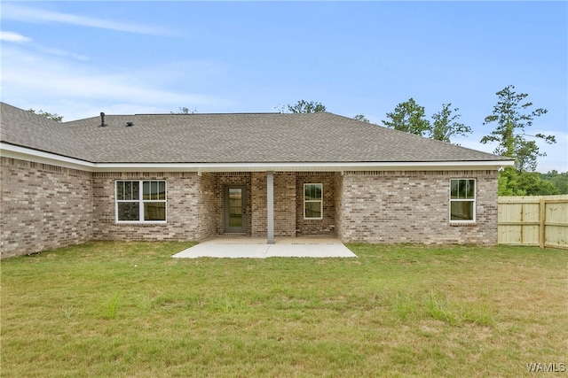 rear view of house featuring a lawn and a patio area