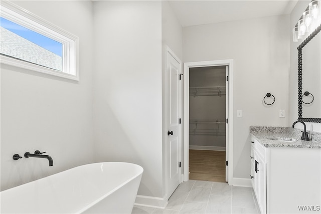 bathroom featuring hardwood / wood-style floors, vanity, and a bathing tub