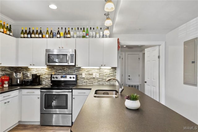 kitchen featuring sink, stainless steel appliances, white cabinets, and pendant lighting