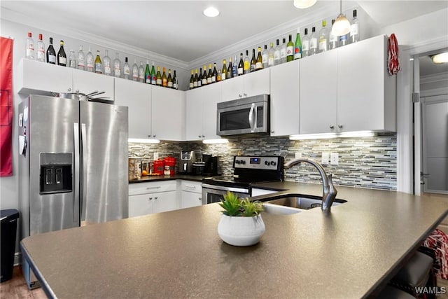 kitchen featuring backsplash, white cabinets, appliances with stainless steel finishes, ornamental molding, and sink