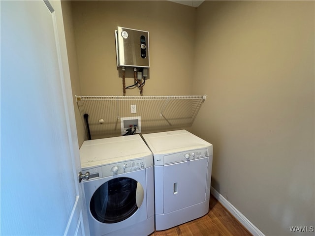 clothes washing area with hardwood / wood-style flooring, separate washer and dryer, and water heater