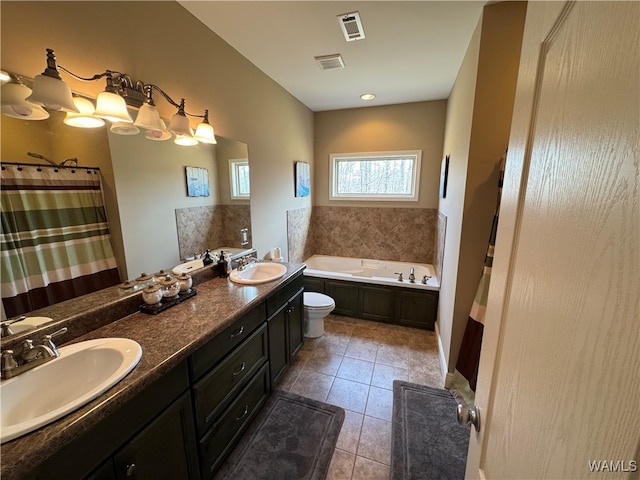 bathroom with toilet, vanity, a bathtub, and tile patterned floors