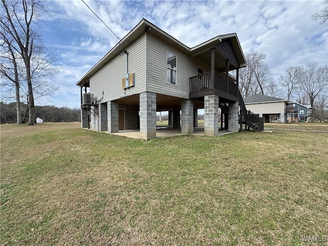 exterior space featuring a balcony, central AC unit, a patio, and a lawn