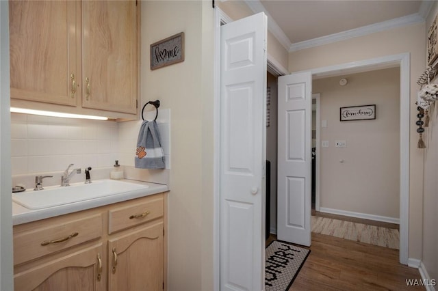 1606 Mallard Cir, Tuscaloosa, AL 35405 - laundry area with a sink, ornamental molding, wood finished floors, and baseboards