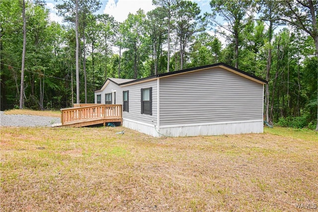 14371 Paul Mills Rd, Buhl, AL 35446 - view of home's exterior featuring a wooden deck, a lawn, and view of wooded area
