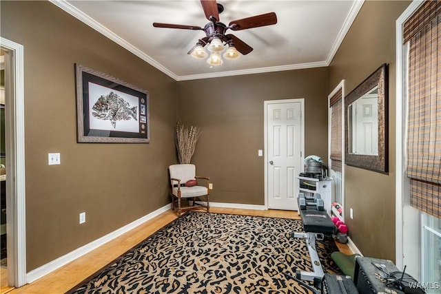 interior space featuring baseboards, ornamental molding, ceiling fan, and wood finished floors