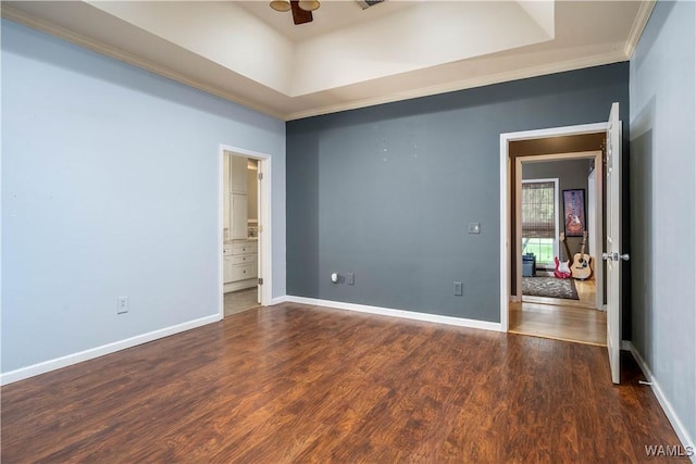 unfurnished bedroom with crown molding, a raised ceiling, and wood finished floors