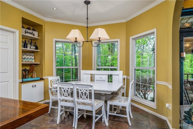 dining space with crown molding, built in features, plenty of natural light, and stone finish flooring
