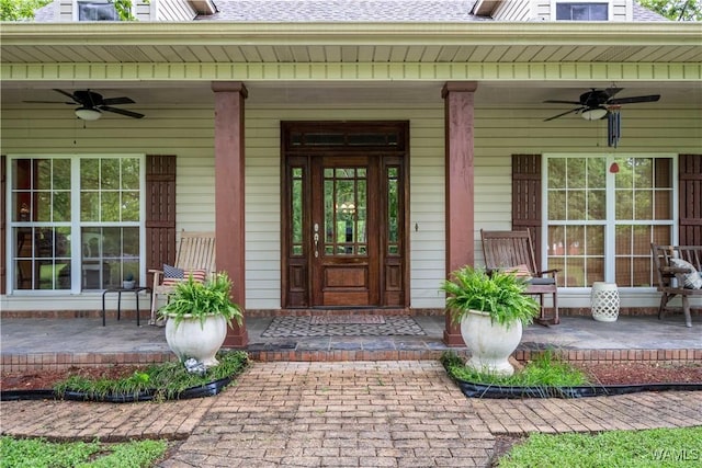 view of exterior entry with a porch, ceiling fan, and roof with shingles