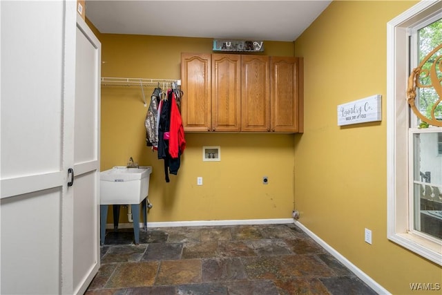 laundry area with baseboards, hookup for a washing machine, stone finish floor, cabinet space, and hookup for an electric dryer