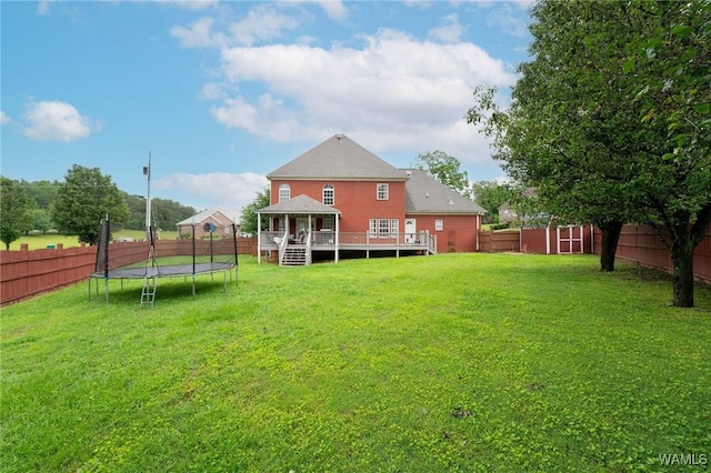 back of property with a trampoline, a deck, and a gazebo