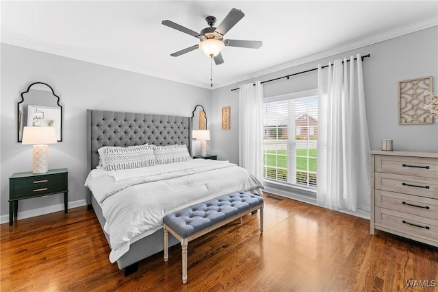 bedroom with wood finished floors, crown molding, baseboards, and a ceiling fan