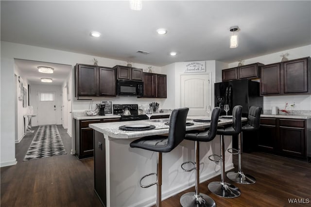 11621 Cedar Glades Dr, Vance, AL 35490 - kitchen featuring black appliances, light countertops, dark brown cabinetry, a kitchen breakfast bar, and dark wood finished floors