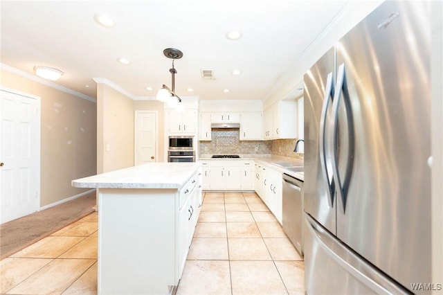 kitchen with crown molding, appliances with stainless steel finishes, decorative light fixtures, a kitchen island, and white cabinetry