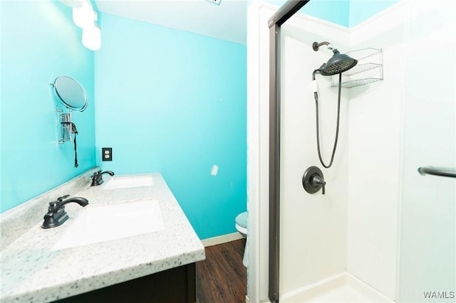 bathroom featuring hardwood / wood-style floors, vanity, toilet, and walk in shower