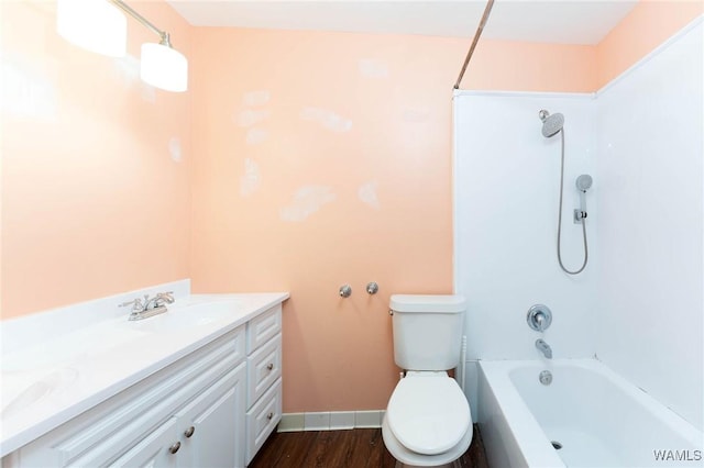 full bathroom featuring hardwood / wood-style flooring, vanity, toilet, and washtub / shower combination