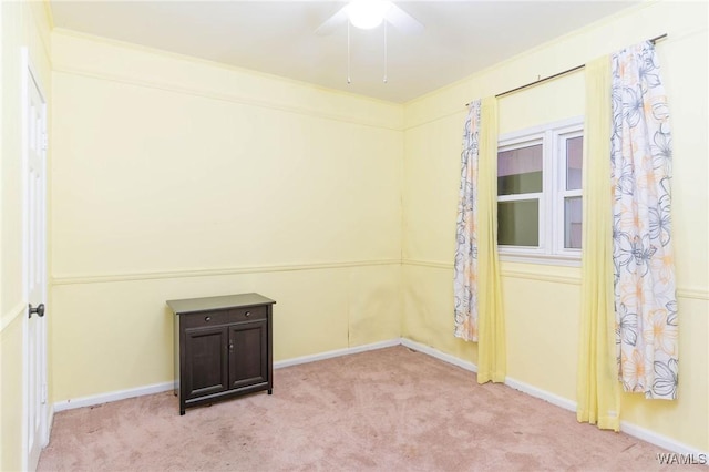 carpeted spare room with ceiling fan and crown molding