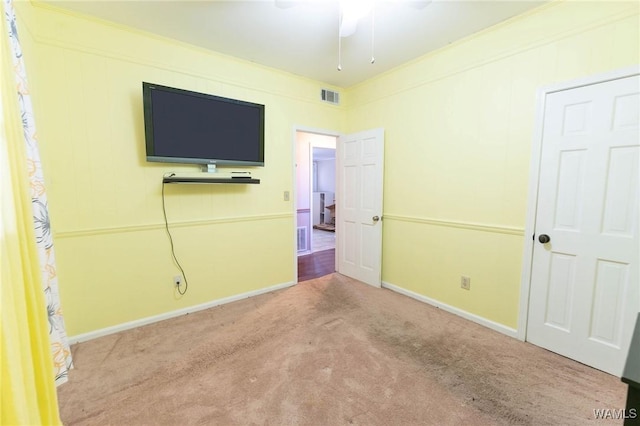 unfurnished bedroom with ceiling fan, light colored carpet, and ornamental molding