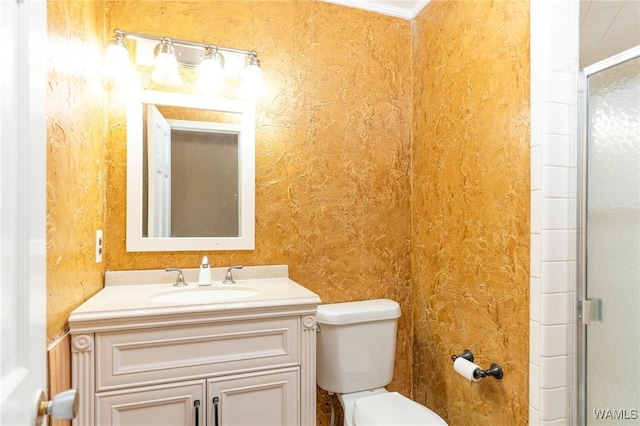 bathroom with vanity, toilet, ornamental molding, and walk in shower