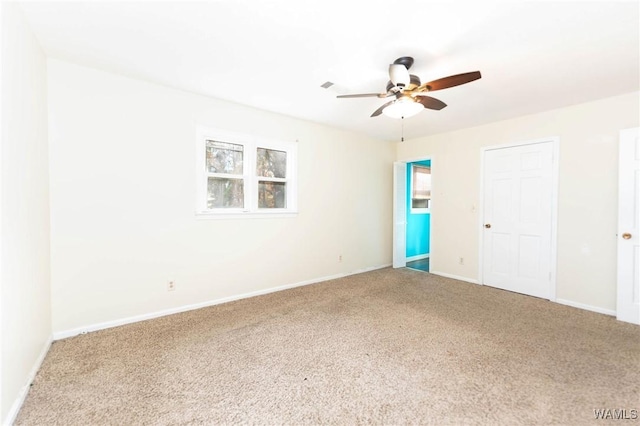 carpeted spare room with ceiling fan