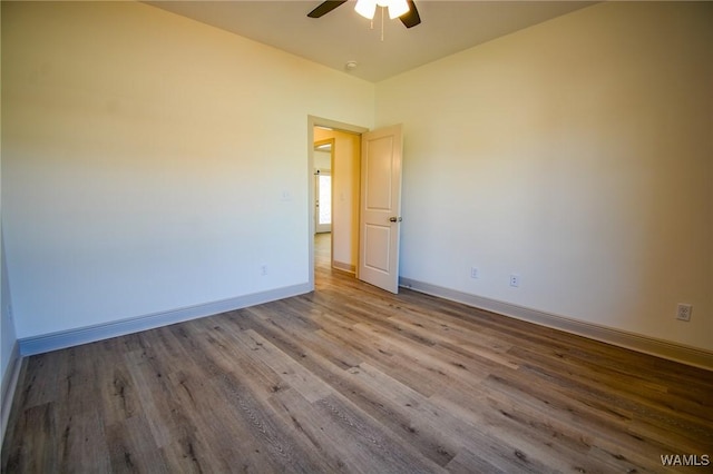 unfurnished room with ceiling fan, wood finished floors, and baseboards