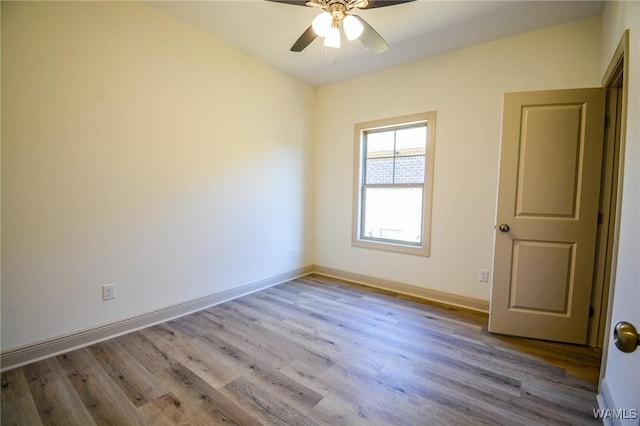 spare room featuring a ceiling fan, baseboards, and wood finished floors