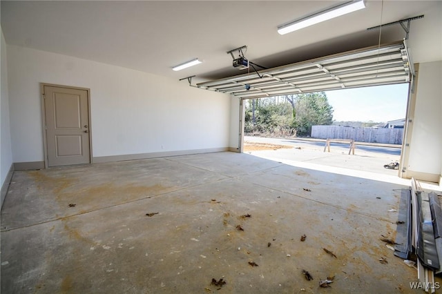 garage featuring a garage door opener and baseboards