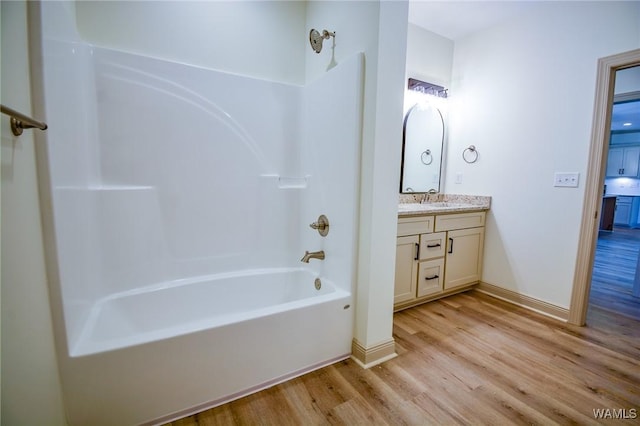 full bathroom with shower / bath combination, baseboards, wood finished floors, and vanity