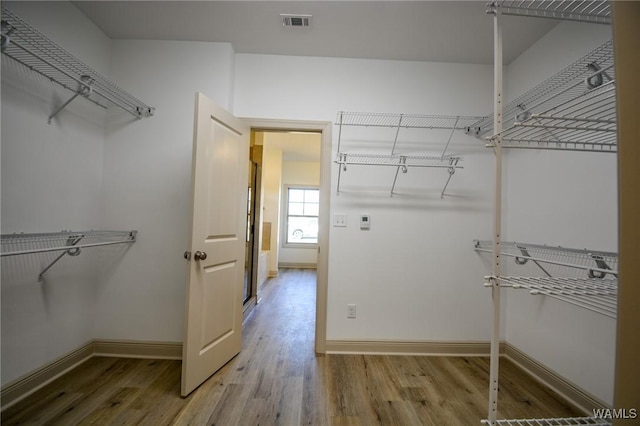 spacious closet featuring visible vents and wood finished floors