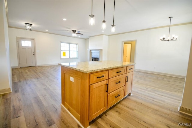 kitchen featuring open floor plan, hanging light fixtures, ornamental molding, and baseboards