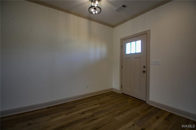 entrance foyer featuring dark wood finished floors, visible vents, crown molding, and baseboards