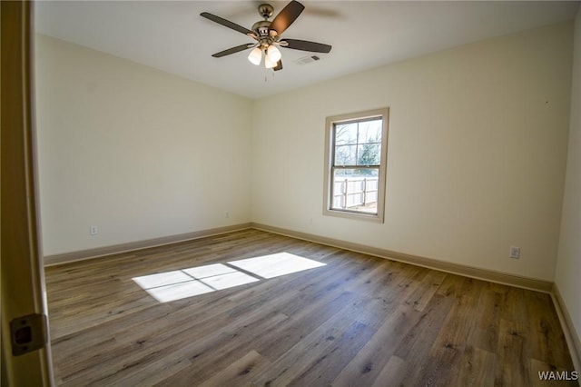 unfurnished room with baseboards and wood finished floors