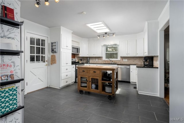 5324 Northwood Lake Dr W, Northport, AL 35473 - kitchen with stainless steel appliances, white cabinets, backsplash, wooden counters, and ornamental molding