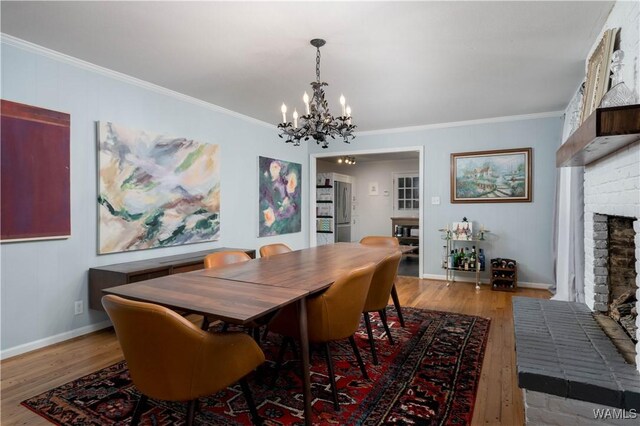 5324 Northwood Lake Dr W, Northport, AL 35473 - dining room with a chandelier, wood finished floors, a fireplace, and ornamental molding