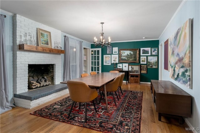 5324 Northwood Lake Dr W, Northport, AL 35473 - dining space featuring ornamental molding, a chandelier, wood finished floors, and a brick fireplace