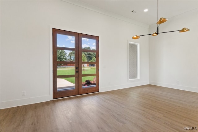 interior space with hardwood / wood-style flooring, crown molding, and french doors