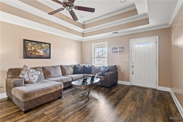 living room featuring crown molding, a tray ceiling, dark wood-type flooring, and ceiling fan