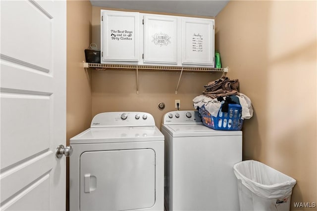 clothes washing area featuring cabinets and washing machine and dryer