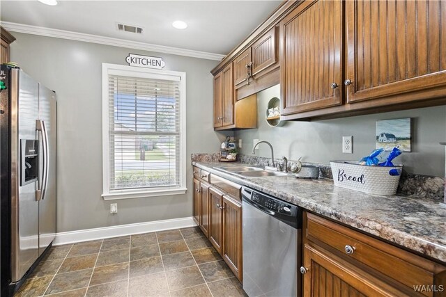 kitchen with dark stone countertops, sink, crown molding, and stainless steel appliances