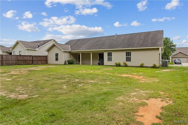 rear view of house featuring a yard and central AC