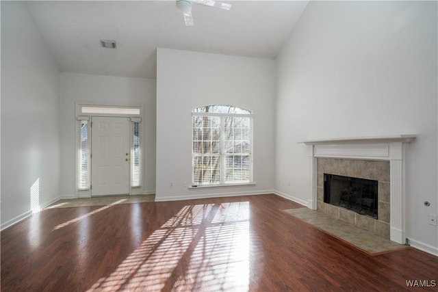 unfurnished living room featuring ceiling fan, wood-type flooring, a fireplace, and vaulted ceiling