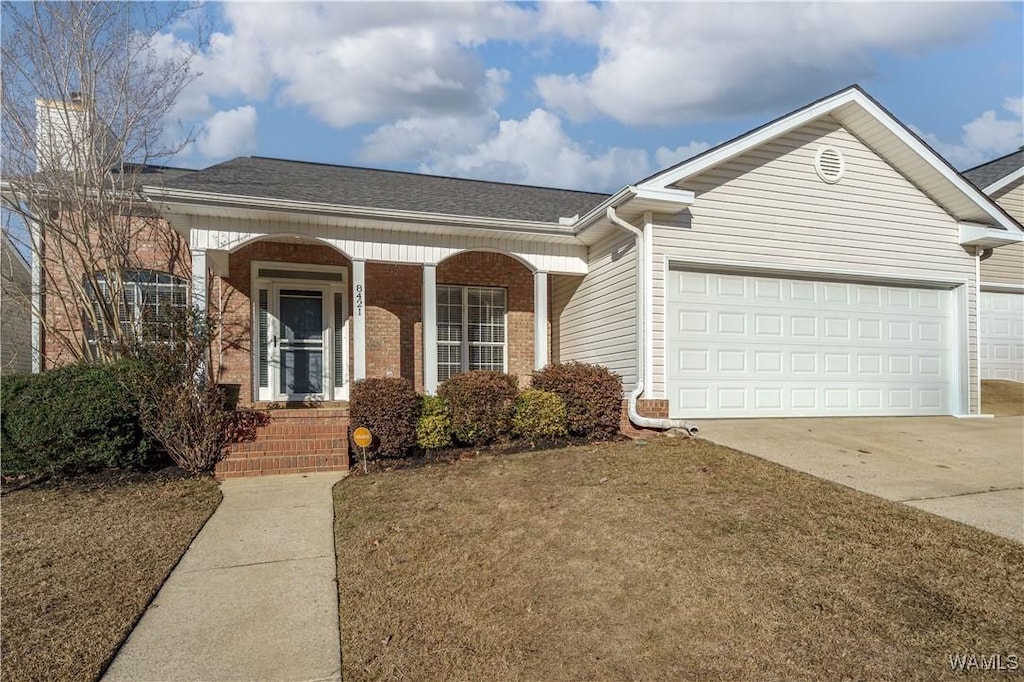 ranch-style house with a garage and a front lawn