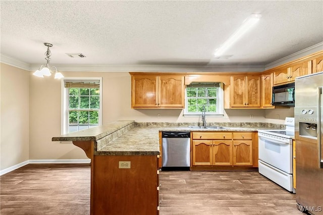7714 Thompsons Way, Northport, AL 35473 - kitchen with appliances with stainless steel finishes, a peninsula, ornamental molding, wood finished floors, and a kitchen bar