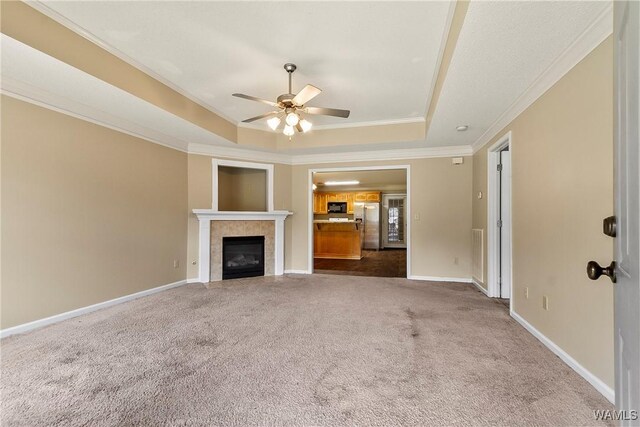 7714 Thompsons Way, Northport, AL 35473 - unfurnished living room with a tray ceiling, carpet floors, ornamental molding, ceiling fan, and a fireplace