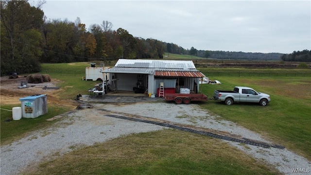 view of front of property with an outbuilding, a rural view, and a front yard