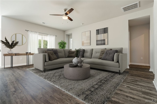 living room featuring dark wood-type flooring and ceiling fan