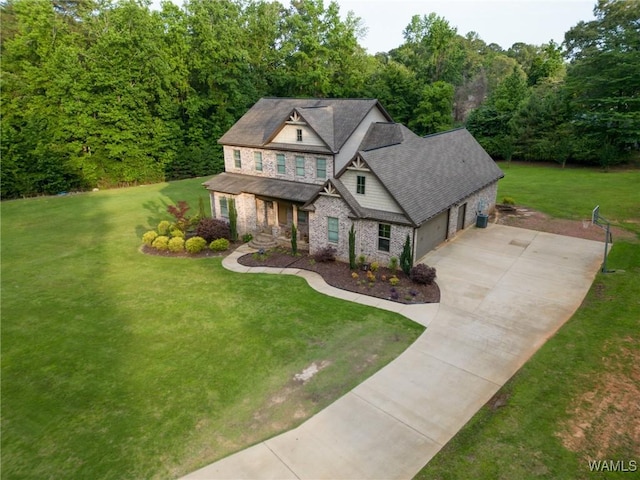 10998 Sleepy Valley Rd, Northport, AL 35475 - craftsman-style house featuring a porch, concrete driveway, a front yard, a garage, and stone siding