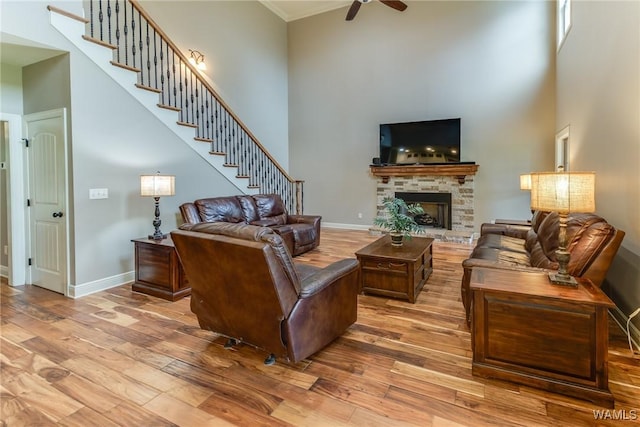 10998 Sleepy Valley Rd, Northport, AL 35475 - living room featuring a towering ceiling, wood finished floors, stairs, ceiling fan, and baseboards