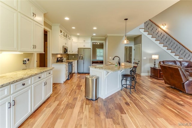 10998 Sleepy Valley Rd, Northport, AL 35475 - kitchen with appliances with stainless steel finishes, open floor plan, light wood-style flooring, crown molding, and white cabinets