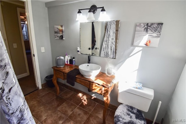 bathroom with a sink, toilet, and tile patterned floors